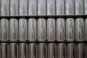 A neatly organized stack of reflective aluminum beverage cans in an industrial setting.
